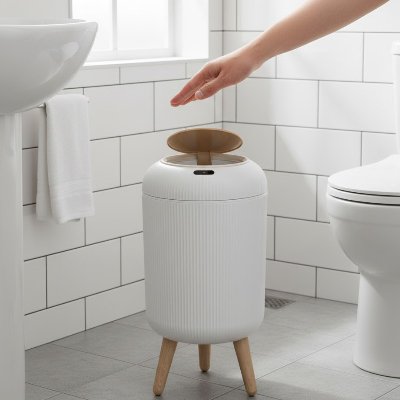 poubelles salle de bains verte sur pieds ouverte main dessus entre lavabo wc