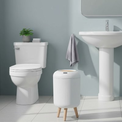 poubelles salle de bains blanche sur pieds fermee entre wc lavabo