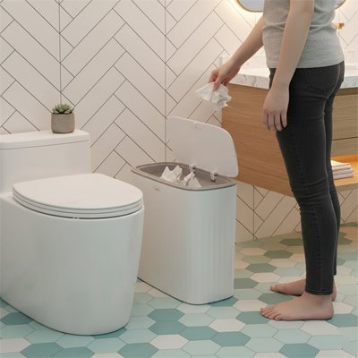 Poubelles salle de bains femme jette papier